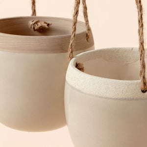 A close-up of the wall hanging planters, support by vintage jute ropes. Showing its smoothing ceramic surface.