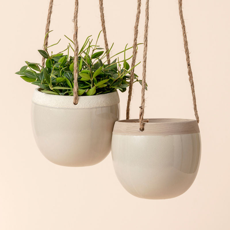 The lush light grey pot set is hanging on the ceiling with jute ropes, showing its color design. The set contains two pots.