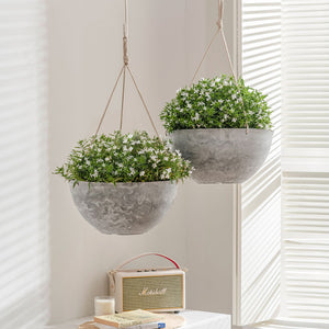 Forged with sustainable plastic and natural stone, this set of hanging planters are displaying white flowers in the living room.