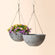 A set of two planters with grey marble patterns, hanging flowers for outdoor displaying with the support from ropes.