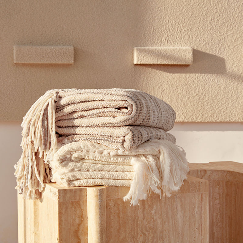 Two ultra-soft chenille throw blankets are stacked on top of each other, showing their fluffy texture.