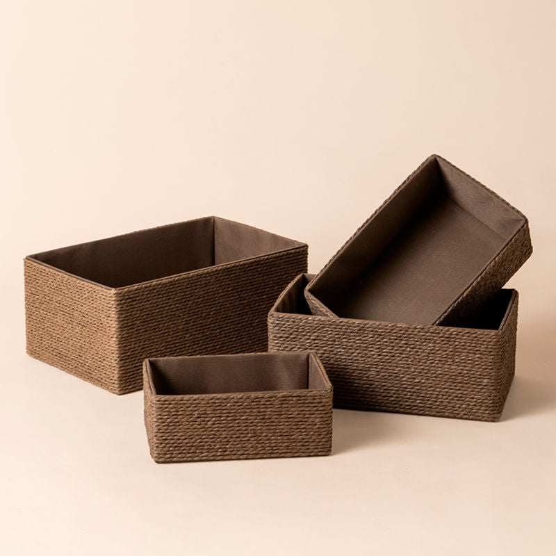 A full view of Izar brown paper rope baskets Set. Four different sizes of storage baskets stand in a staggered way and are stacked.