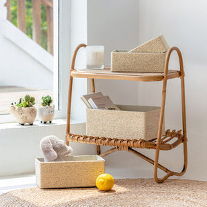 Three of the cream storage baskets are placed on a wooden shelf, behind a medium basket that stores a cute bunny.