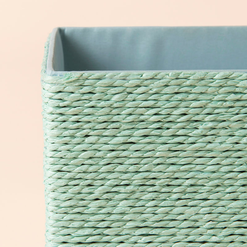 A close-up of cotton rope storage basket, showing its mint woven pattern and inner fabric.