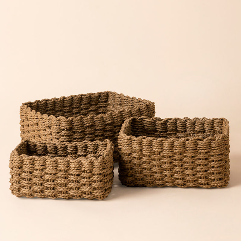 A set of three earthy brown basket, made of durable paper ropes. Three sizes baskets are placed next to each other.