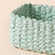 A close-up of paper rope storage basket, showing its green-white mixed pattern and durable feature.