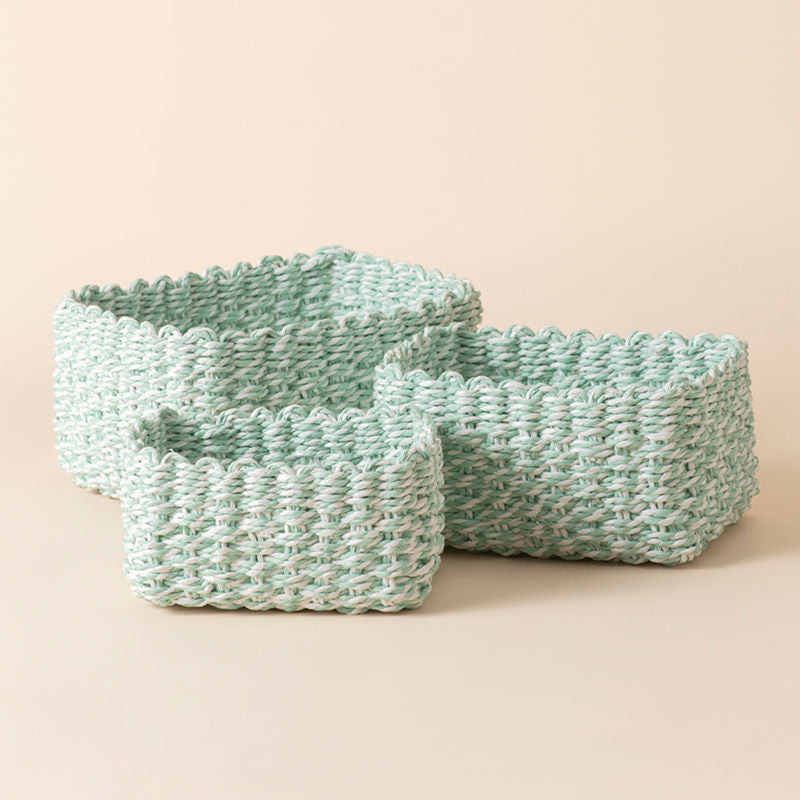 A full view of Kulu green and white paper rope baskets Set. Three different sizes of storage baskets stand in a staggered way.