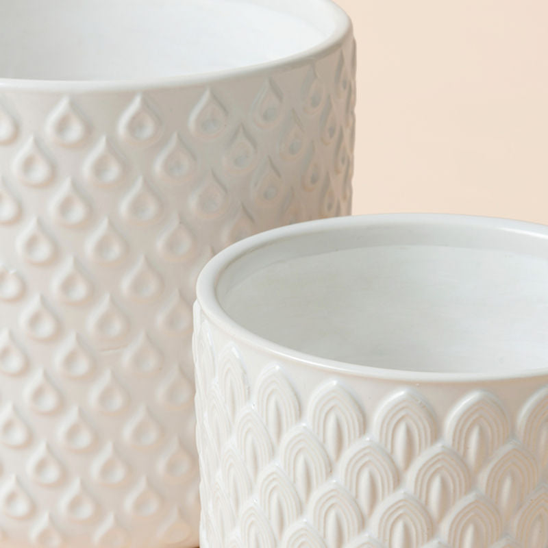 A close up of white ceramic planters, showing their fully glazed body and dimension in  6.3 inches.