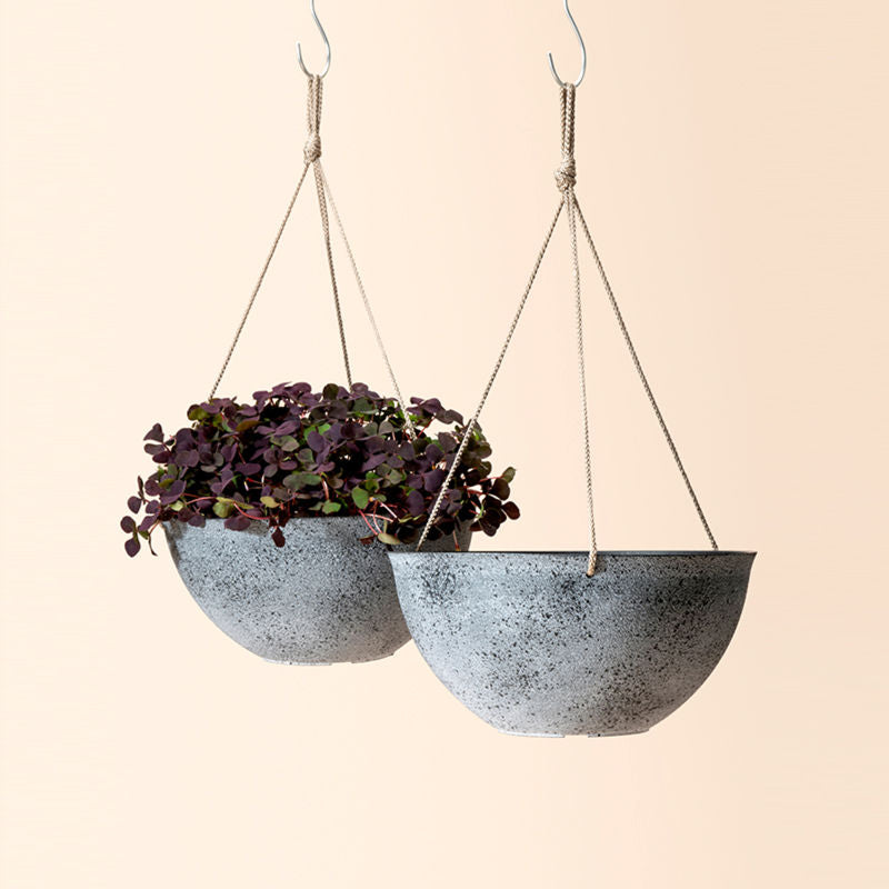 A set of two gray hanging planters, made from recyclable plastic and natural stone powders.