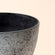 A close up of rock gray planter, showing its industrial style exterior and dimension in 11.3 inches.