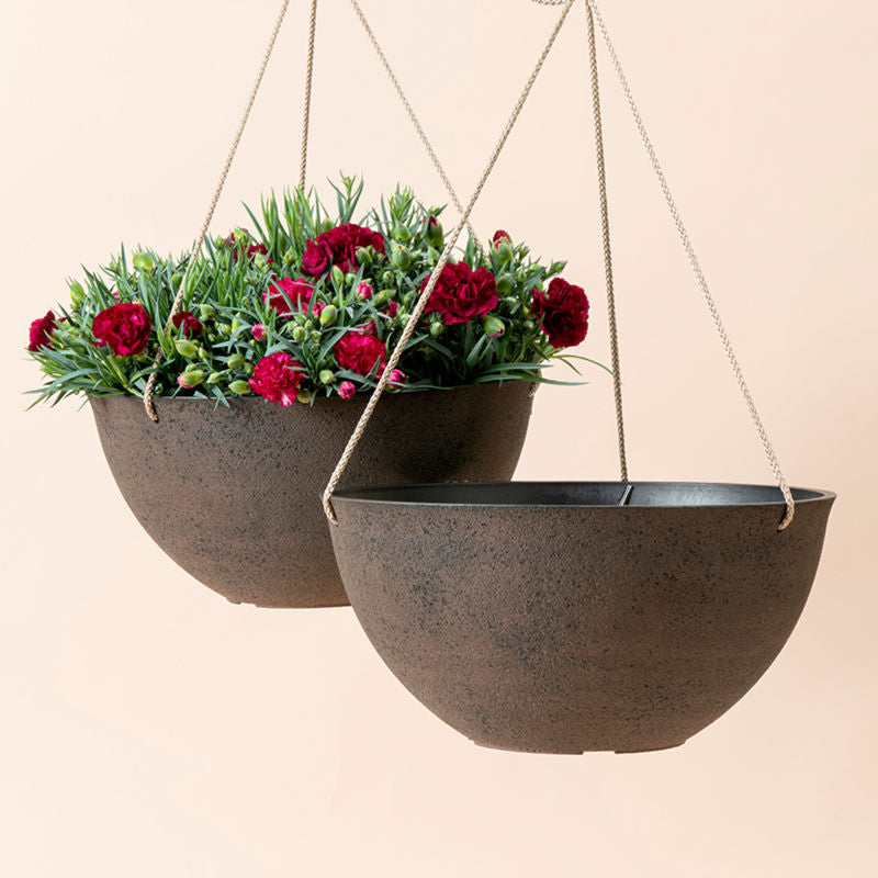 A set of two large hanging planters with rusty exterior, made from recyclable plastic and natural stone powders.