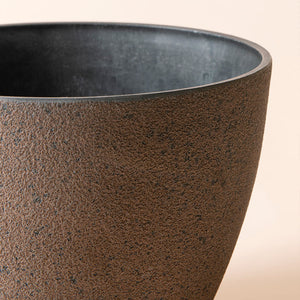 A close up of rusty planter, showing its grainy texture and industrial style exterior.