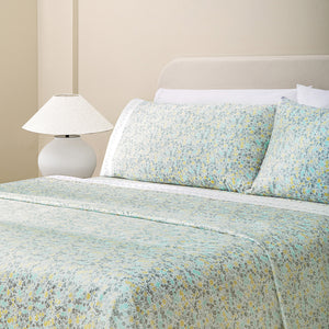 Sofia Yellow and Green Floral 300TC Cotton Sateen Sheet Set set. Yellow and green floral pillows and yellow and white floral sheets on bed with side table and lamp from side angle.