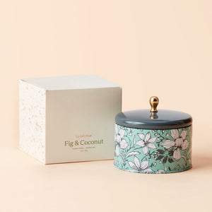 A tin of Fig and Coconut candle with its white packing box.