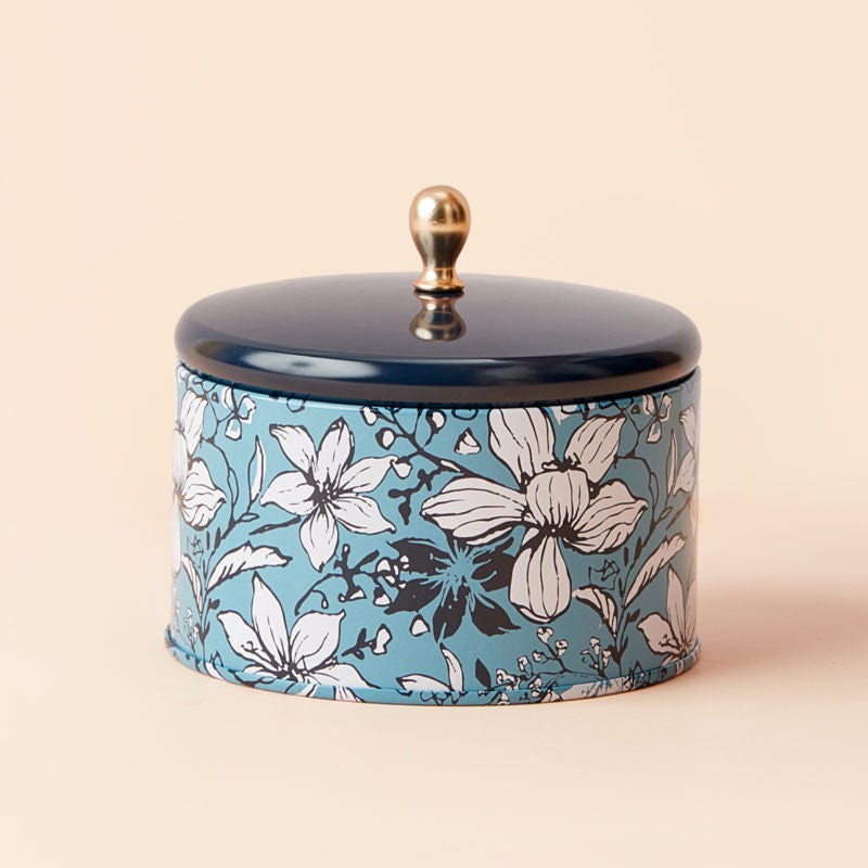 Spearmint and Eucalyptus candle, placed in a blue-based tin with a lid.