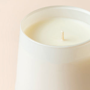 A close up of Vanilla Cake oval candle, showing its cotton wick.