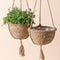 A set of two brown hanging planters in 9 inches, made of flexible seagrass with a interior plastic coating.