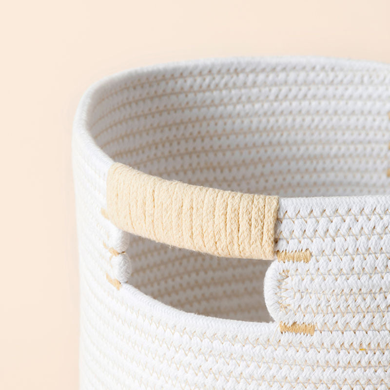 A close up of white cotton rope basket, showing its round shape and reinforced handle.