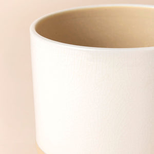 A close up of a white pot, showing its cylindrical body and dimension in 6.5 inches. 