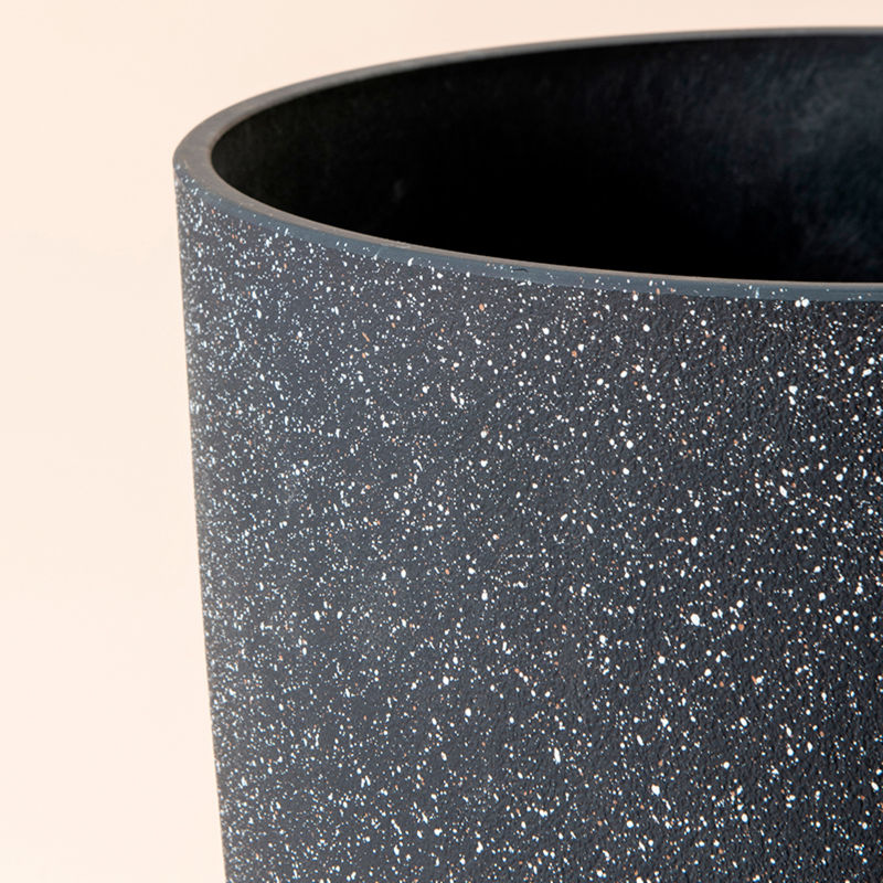 A close up of speckled black planter, showing its concrete texture and large dimension in 20 inches.