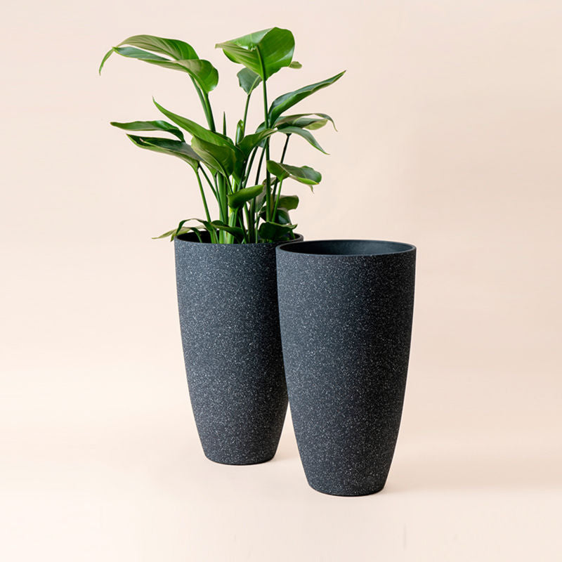 A full view of two speckled black tall pots in same sizes, made from recyclable plastic and natural stone powders.