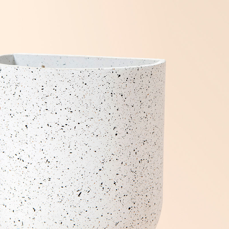 A close view of white wall planter, showing its speckles feature and handmade texture.