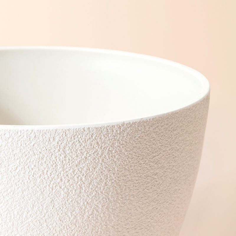 A close-up of the minimalist style white planter, showing its stone pattern around the exterior and the smoothing inside.