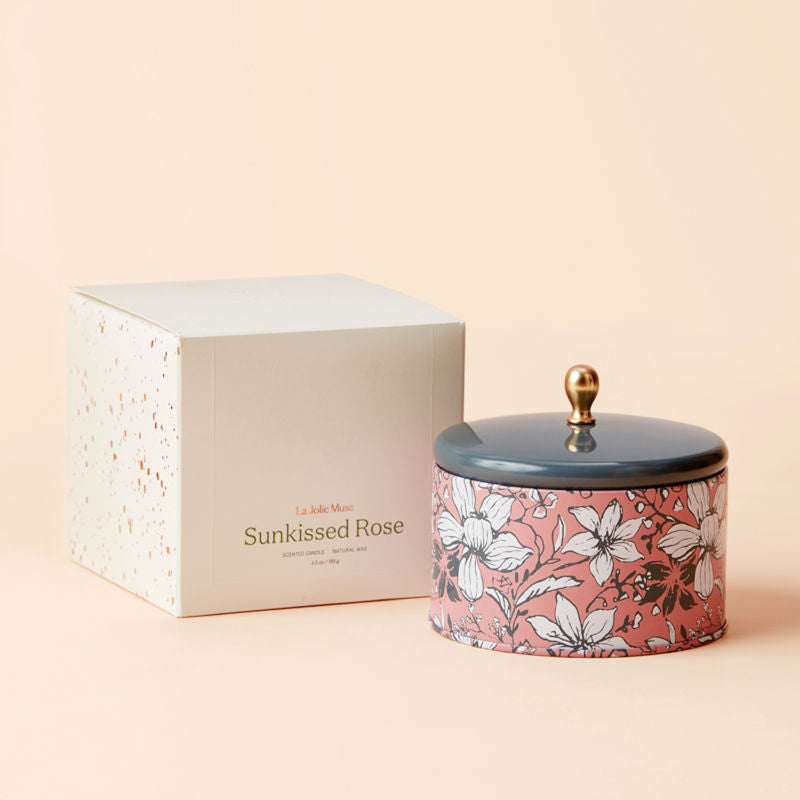 A jar of Sunkissed Rose candle with its white packing box.