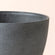 A close up of gray tall planter, showing its concrete texture and large dimension in 20 inches.
