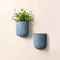 A set of two weathered gray wall planters, made from recyclable plastic and stone powders.