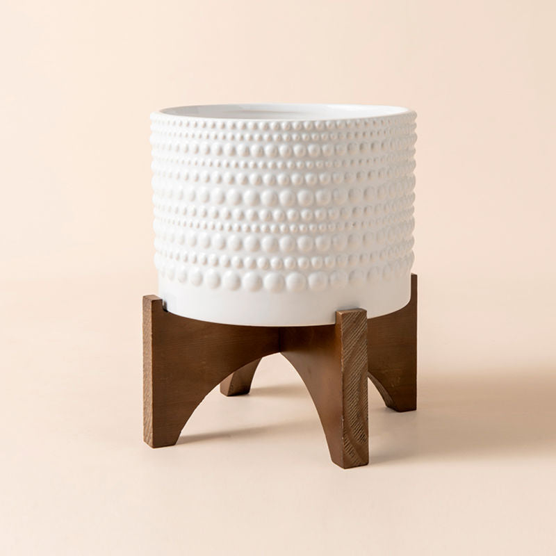 A full view of white bubble dots pot with wooden stand, made of premium ceramic.