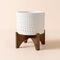 A full view of white bubble dots pot with wooden stand, made of premium ceramic.