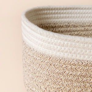 A close up of white and desert cotton rope basket, showing its fabric texture and dual-colored design.