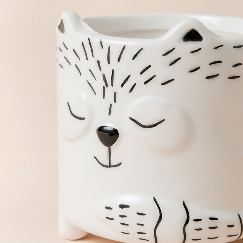 A close-up of the small planter, with a fox face that is painted around the exterior surface. Showing its cute design and ceramic feature.