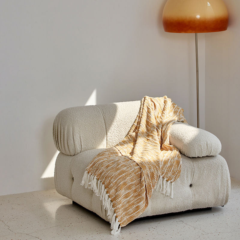The white and yellow throw blanket is placed on a white couch, showing one of its usage for an afternoon nap.