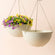 A set of two large hanging planters in speckled yellow color, made from  plastic and stone powders.