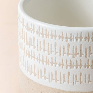 A close up of zen beige pot, showing thee loose cross-hatched design around its exterior.